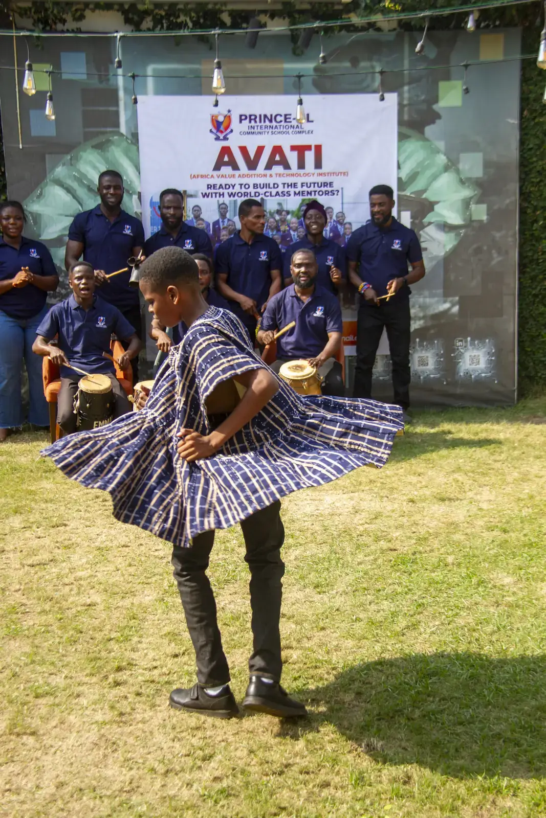 A member dancing in a smock as the drummers play.